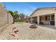 Landscaped backyard featuring a charming fire pit, desert landscaping, and a covered patio for outdoor living at 17292 W Pinnacle Vista Dr, Surprise, AZ 85387