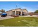 Spacious backyard with artificial turf, a covered patio, and desert landscaping at 17292 W Pinnacle Vista Dr, Surprise, AZ 85387