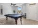 Bright game room with a large covered pool table, and a sunlit window with natural lighting at 17292 W Pinnacle Vista Dr, Surprise, AZ 85387
