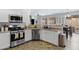 Updated kitchen features stainless steel appliances and white cabinetry with a view to the dining room at 17292 W Pinnacle Vista Dr, Surprise, AZ 85387