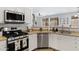 Updated kitchen features stainless steel appliances and white cabinetry with a view to the dining room at 17292 W Pinnacle Vista Dr, Surprise, AZ 85387