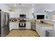 Bright kitchen with stainless steel appliances, white cabinets, and a view into the living area at 17292 W Pinnacle Vista Dr, Surprise, AZ 85387
