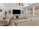 Inviting living room with neutral-toned furniture, a ceiling fan, and a modern entertainment center at 17292 W Pinnacle Vista Dr, Surprise, AZ 85387