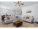 Cozy living room with modern furnishings, a ceiling fan, and an open layout to the dining area at 17292 W Pinnacle Vista Dr, Surprise, AZ 85387