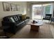 Comfortable living room showcasing a leather sofa, neutral tones, and access to a private patio at 1823 E Kirkland Ln # C, Tempe, AZ 85281