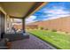 Backyard featuring a covered patio with comfortable seating and a lush green lawn at 19968 W Flower St, Buckeye, AZ 85396