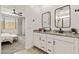 Contemporary bathroom with dual sinks, modern fixtures, and a view into the main bedroom at 19968 W Flower St, Buckeye, AZ 85396
