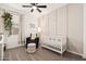 A serene Bedroom with soft lighting, neutral tones, a crib, and a comfortable chair with ottoman at 19968 W Flower St, Buckeye, AZ 85396