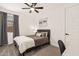 Bright bedroom featuring a bed with gray headboard, gray curtains and modern abstract art at 19968 W Flower St, Buckeye, AZ 85396