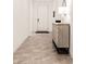 Bright hallway featuring tile flooring and an accent cabinet with decor at 19968 W Flower St, Buckeye, AZ 85396