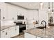 Well-lit kitchen with stainless steel appliances, a granite countertop island, and white cabinetry at 19968 W Flower St, Buckeye, AZ 85396