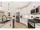 Open kitchen featuring stainless steel appliances, granite countertops, and white cabinets at 19968 W Flower St, Buckeye, AZ 85396