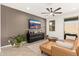 Comfortable living room featuring a tan leather couch, ceiling fan and sleek media console at 19968 W Flower St, Buckeye, AZ 85396