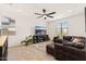 Comfortable living room with tile floors, a ceiling fan, and a leather sectional at 19968 W Flower St, Buckeye, AZ 85396