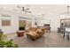 Open-concept living area featuring a leather couch, stylish ceiling fan and backyard access at 19968 W Flower St, Buckeye, AZ 85396