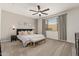 Relaxing primary bedroom with a ceiling fan, neutral tones and a plush upholstered headboard at 19968 W Flower St, Buckeye, AZ 85396
