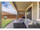 Covered patio with comfortable seating, a modern fire pit, and a well-maintained lawn at 19968 W Flower St, Buckeye, AZ 85396