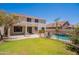 Spacious backyard with a fenced pool, lush grass, patio seating, and a two-story home at 2102 S Sabrina --, Mesa, AZ 85209