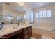 Bright bathroom featuring a large soaking tub, glass shower, and double sink vanity at 2102 S Sabrina --, Mesa, AZ 85209