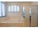 Bright bathroom featuring a large soaking tub, glass shower, and white neutral colors at 2102 S Sabrina --, Mesa, AZ 85209