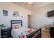 Bright bedroom with light walls, wood-look flooring, ceiling fan, door to bathroom, and a whimsical decor theme at 2102 S Sabrina --, Mesa, AZ 85209