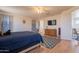 Bright main bedroom with a ceiling fan, a blue patterned rug, and wood-look floors at 2102 S Sabrina --, Mesa, AZ 85209