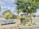 Patio Gardens Mobile Home Park sign with mature trees and cacti landscaping in a 55+ community at 318 S Crismon Rd # 65, Mesa, AZ 85208