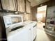 This laundry room features a white washer and dryer, wooden cabinets, and shelving at 318 S Crismon Rd # 65, Mesa, AZ 85208