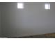 Minimalist bedroom with white walls, light wood floors and two small high windows at 34449 N Elk Run Rd, San Tan Valley, AZ 85143