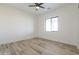 Bright bedroom with wood-look floors, a modern ceiling fan, and a window with natural light at 34449 N Elk Run Rd, San Tan Valley, AZ 85143