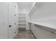 Walk-in closet featuring built-in shelving and wood-look tile floors, providing ample storage space at 34449 N Elk Run Rd, San Tan Valley, AZ 85143