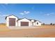Modern home exterior with multi-car garage featuring a spacious driveway and well-maintained desert landscaping at 34449 N Elk Run Rd, San Tan Valley, AZ 85143