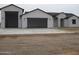 Modern home featuring multiple garage spaces and a white stucco facade with black trim at 34449 N Elk Run Rd, San Tan Valley, AZ 85143