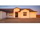 Front facade of a stucco home with a statement front door and desert landscape, perfect for a modern lifestyle at 34449 N Elk Run Rd, San Tan Valley, AZ 85143