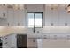 Kitchen featuring white cabinetry, a farmhouse sink, quartz countertop and stainless steel appliances at 34449 N Elk Run Rd, San Tan Valley, AZ 85143