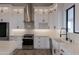 Close-up of the gourmet kitchen featuring white cabinets, quartz countertops and stainless steel appliances at 34449 N Elk Run Rd, San Tan Valley, AZ 85143