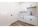 Laundry room features white cabinets, black hardware, and quartz countertop at 34449 N Elk Run Rd, San Tan Valley, AZ 85143