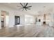 Open-concept living space showcasing kitchen, dining, and living areas with wood-look tile flooring at 34449 N Elk Run Rd, San Tan Valley, AZ 85143