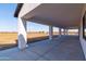 Spacious covered patio with concrete flooring and large support columns, perfect for outdoor entertaining at 34449 N Elk Run Rd, San Tan Valley, AZ 85143