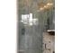 Glass-enclosed shower features grey marble-style tile, rain shower head, and stylish black hardware at 34449 N Elk Run Rd, San Tan Valley, AZ 85143