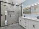 Modern bathroom with a glass-enclosed shower, double vanity with quartz countertops, and a well-lit LED mirror at 3623 S 78Th Dr, Phoenix, AZ 85043