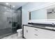 Modern bathroom featuring dual sinks, a walk-in shower with black marble, and an illuminated mirror at 3623 S 78Th Dr, Phoenix, AZ 85043