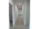 Long hallway with neutral tile flooring leading to the front door of the house at 38150 W Bello Ln, Maricopa, AZ 85138