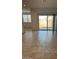 Open living area with tile flooring, large sliding glass doors to the backyard, and natural light at 38150 W Bello Ln, Maricopa, AZ 85138