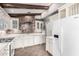 Bright kitchen with white cabinets, white appliances, stone wall accent and wood beams at 3913 E Derringer Way, Gilbert, AZ 85297