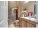 Well-lit bathroom features a glass-enclosed shower, tile accents, and a vanity with decorative countertop at 42023 N Bridlewood Way, Anthem, AZ 85086