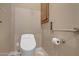 A well-lit bathroom with a modern commode and stainless steel handrail, designed for accessibility at 42023 N Bridlewood Way, Anthem, AZ 85086