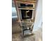 Modern stainless steel oven and warming drawer with sleek design integrated into custom kitchen cabinetry at 42023 N Bridlewood Way, Anthem, AZ 85086