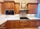 Well-equipped kitchen featuring stainless steel appliances, custom cabinetry, and stylish backsplash at 42023 N Bridlewood Way, Anthem, AZ 85086