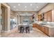 Open kitchen with marble countertops, stainless appliances, island, and bar seating overlooking backyard at 42023 N Bridlewood Way, Anthem, AZ 85086